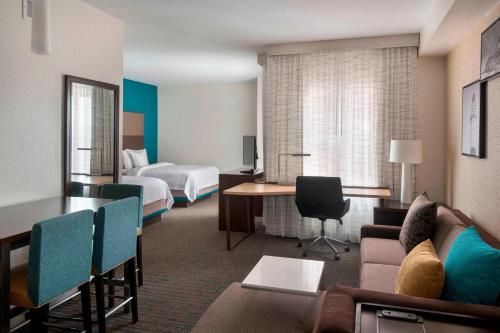 a hotel room with a bed and a living room at Residence Inn by Marriott New York Long Island East End in Riverhead