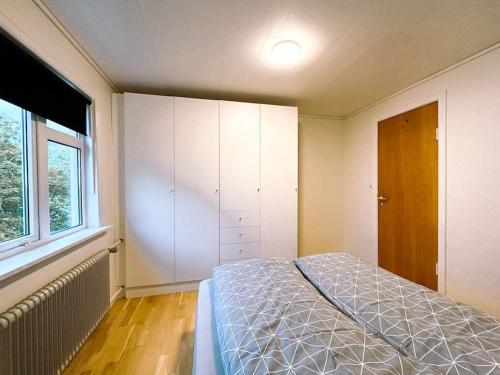 a bedroom with a bed and a large window at Cozy apartment in Klaksvík in Klaksvík