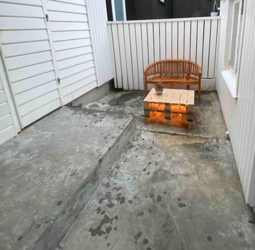 a bench sitting on a patio next to a fence at Cozy apartment in Klaksvík in Klaksvík