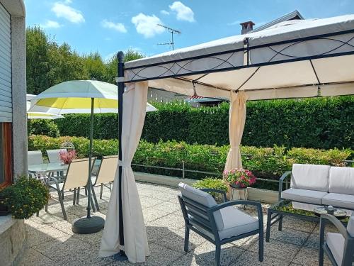 a patio with tables and chairs under an umbrella at Casa Germana in Invorio Inferiore