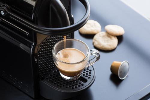 eine Tasse Kaffee wird in einen Toaster gegossen in der Unterkunft U Boutique Kinneret by the Sea of Galilee in Tiberias