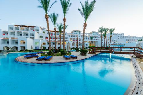 a large pool with palm trees in front of a hotel at Siva Sharm Resort & SPA in Sharm El Sheikh