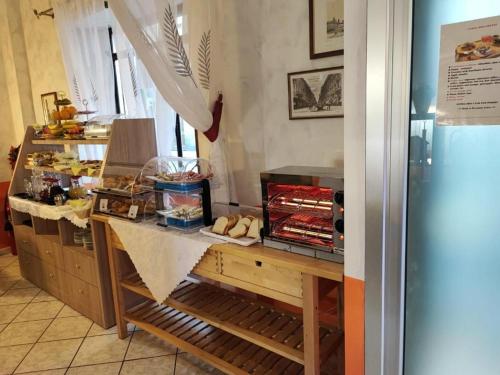a kitchen with a counter with bread and a refrigerator at Hotel Orchidea in Turin