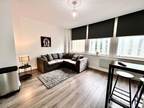 a living room with a couch and a table at Modern Central 5 Bed Apartment in Liverpool