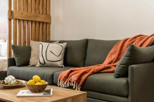 a living room with a green couch and a table at KOYO Athens in Athens