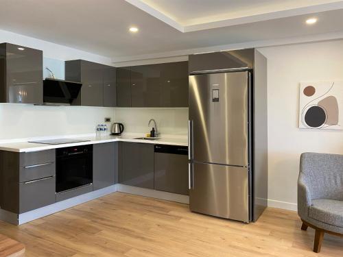 a kitchen with a stainless steel refrigerator and a chair at Veranda Suites in Antalya