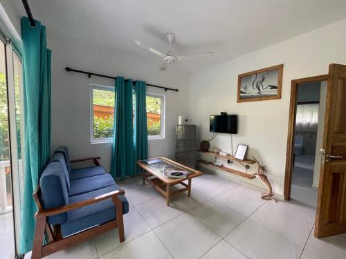 a living room with a blue couch and a tv at FOND B'OFFAY LODGE in Victoria