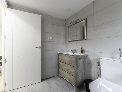 Baño blanco con lavabo y espejo en Munoa By Kabia Gestion, en Barakaldo