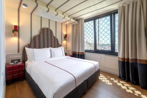 a bedroom with a large bed and a large window at Khai Karaköy in Istanbul