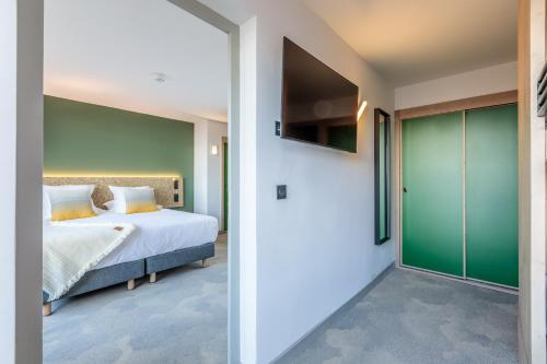 a bedroom with a bed and a green door at La Cachette, Friendly Hotel & Spa in Arc 1600