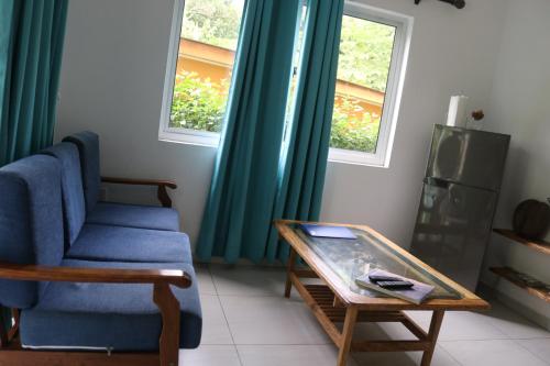 a living room with a blue couch and a coffee table at FOND B'OFFAY LODGE in Victoria