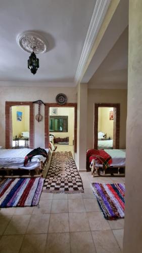 a large room with two beds and two rugs at auberge gite de jeunesse les Cascades in Setti Fatma