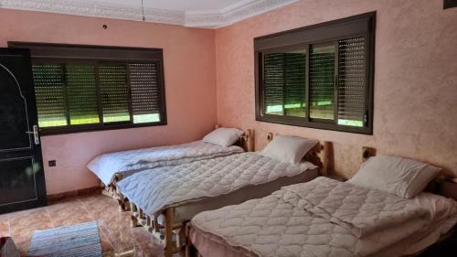 - 2 lits dans une chambre avec 2 fenêtres dans l'établissement auberge gite de jeunesse les Cascades, à Sti Fadma