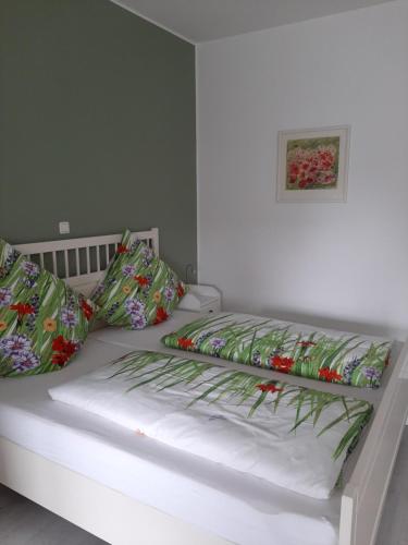 a white bed with pillows and a picture on the wall at barrierefreie Apartments in Kerken