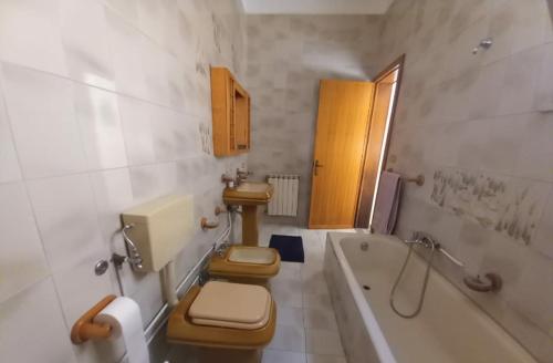 a bathroom with two toilets and a tub and a sink at La Casina Di Nonna Ida in Ruffano