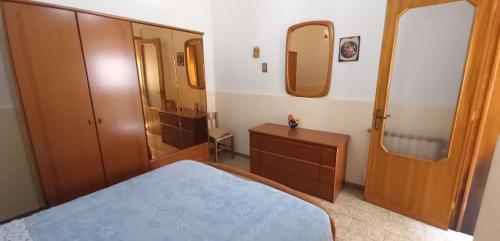 a bedroom with a bed and a dresser and a mirror at La Casina Di Nonna Ida in Ruffano