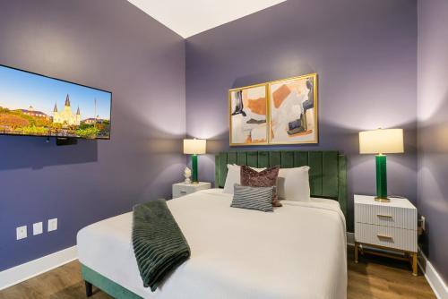 um quarto com uma cama grande e uma televisão na parede em Exquisite 4 Bedroom Luxury condo Just Steps from the French Quarter em Nova Orleans