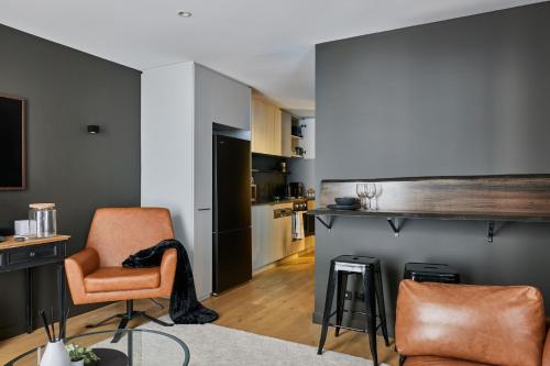 a living room with a table and chairs and a kitchen at The Yorkshire Apartments Collingwood in Melbourne