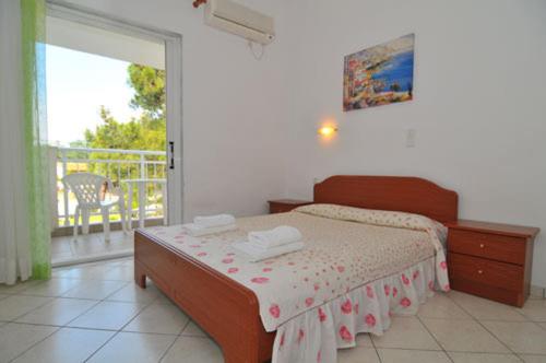 a bedroom with a bed and a balcony at Villa Iris in Prinos