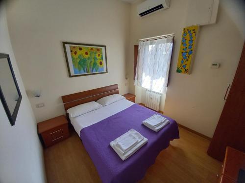 1 dormitorio con 1 cama con manta morada en Casa Campo de' Fiori, en Roma