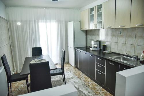 een keuken met een tafel en een laptop bij Apartament 3 camere In centru in Râmnicu Vâlcea
