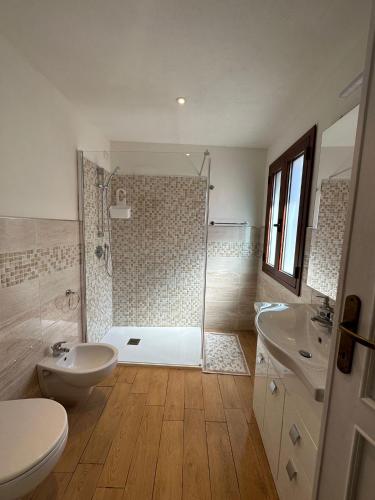 ein Badezimmer mit Dusche, Toilette und Waschbecken in der Unterkunft Ninfa Alghero in Alghero