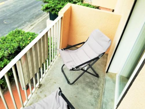 納博訥濱海的住宿－納博訥普拉日美岸公寓，阳台的白色椅子