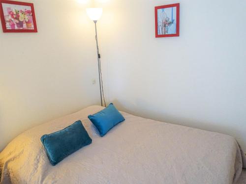 Cette chambre comprend un lit doté de 2 oreillers bleus. dans l'établissement Apartment Les Balcons de la Méditerranée-14 by Interhome, à Narbonne-Plage