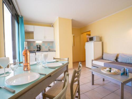 une cuisine et un salon avec une table et des chaises dans l'établissement Apartment Les Rivages de Rochelongue-2 by Interhome, au Cap d'Agde