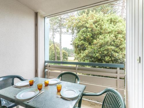 una mesa con platos en el balcón en Apartment Village Cheval Spa Résidences-3 by Interhome, en Lacanau-Océan