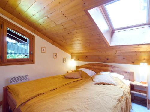 une chambre avec un grand lit avec un plafond en bois dans l'établissement Apartment Le Tagre by Interhome, à Mémontel