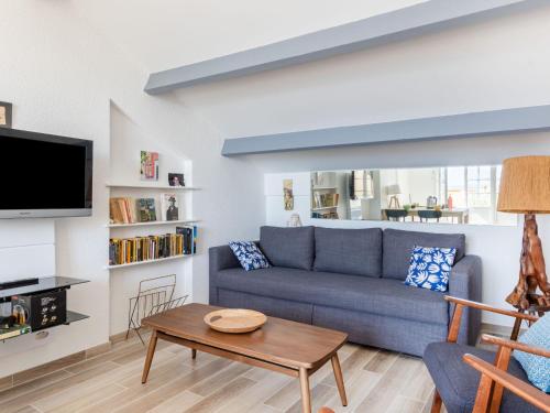 un salon avec un canapé bleu et une table dans l'établissement Apartment Château de la Madrague-2 by Interhome, à La Madrague