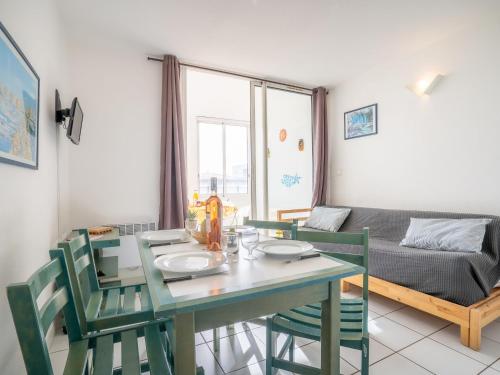 uma sala de jantar com uma mesa e cadeiras e um sofá em Apartment La Palme d'Or-4 by Interhome em Cap d'Agde