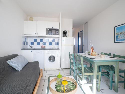 uma sala de estar com uma mesa e uma cozinha com uma mesa; em Apartment La Palme d'Or-4 by Interhome em Cap d'Agde