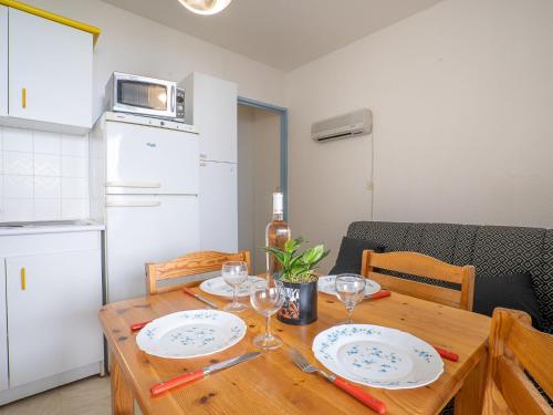 - une table à manger avec des assiettes et des verres à vin dans l'établissement Apartment Le Beaupré-2 by Interhome, à Canet