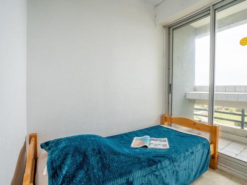 - un lit avec une couverture bleue et un livre dans l'établissement Apartment Le Beaupré-2 by Interhome, à Canet