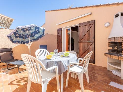 - une table et des chaises sur la terrasse d'une maison dans l'établissement Holiday Home Les Leucatines 3 by Interhome, à Port-Leucate