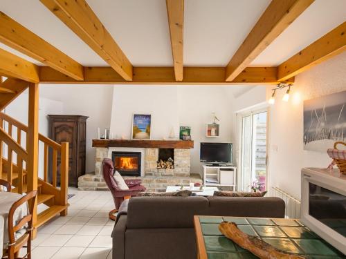 a living room with a couch and a fireplace at Holiday Home Tal Ar Mor - PLC213 by Interhome in Plounévez-Lochrist