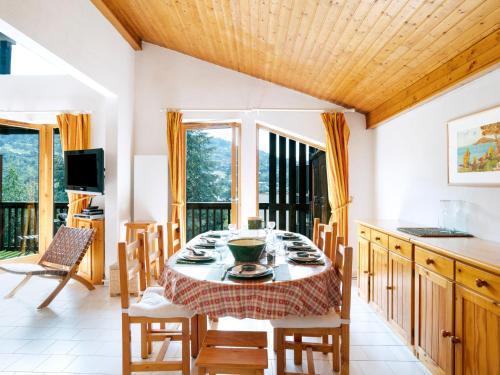 a dining room with a table and chairs and windows at Apartment le Martagon-1 by Interhome in Saint-Gervais-les-Bains