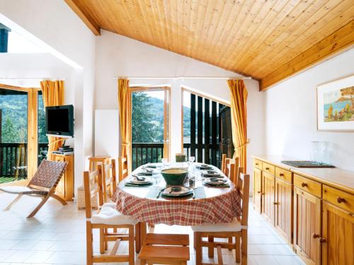 une salle à manger avec une table, des chaises et des fenêtres dans l'établissement Apartment Martagon-1 by Interhome, à Saint-Gervais-les-Bains