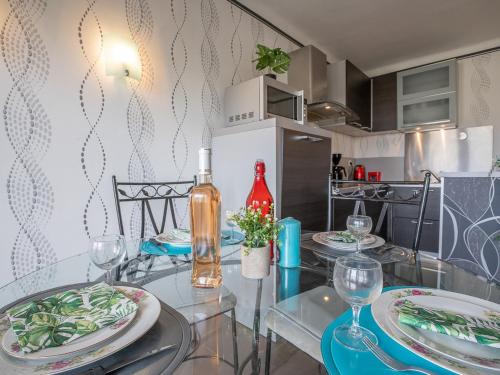 une cuisine avec une table avec des assiettes et des verres à vin dans l'établissement Apartment Le régent-1 by Interhome, à Canet
