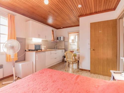 une cuisine avec des armoires blanches et un plafond en bois dans l'établissement Apartment Le Soleil Camarguais-1 by Interhome, à Saintes-Maries-de-la-Mer