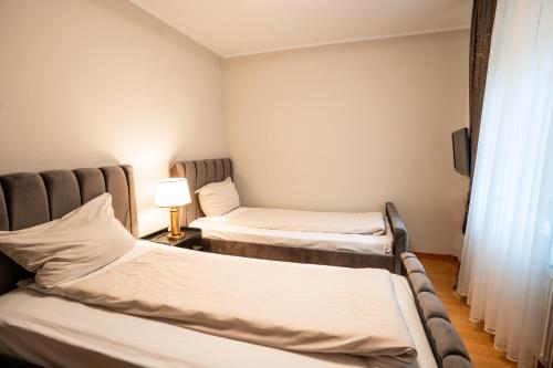 two beds in a small room with a window at Hotel CityHome am Kurpark in Bad Salzuflen