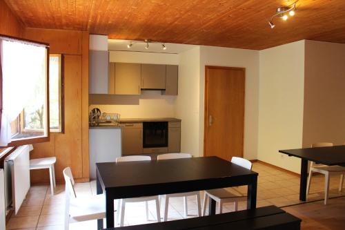 a kitchen and dining room with a black table and chairs at La Pierre à Catillon in Moleson