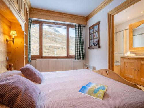 a bedroom with a bed with a book on it at Apartment Le Bec Rouge - Le Lac-2 by Interhome in Tignes