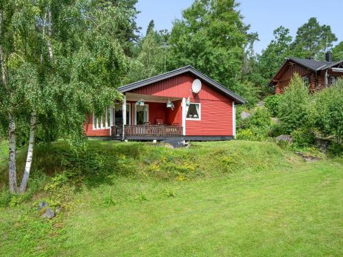 a red house on a hill with a yard at Chalet Västanvik Snickarhagen by Interhome in Motala