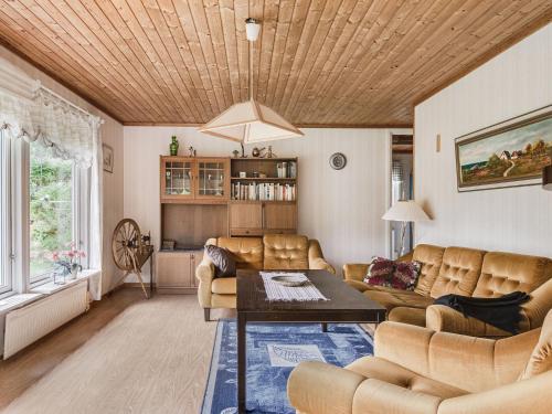 uma sala de estar com um sofá e uma mesa em Chalet Västanvik Snickarhagen - OST047 by Interhome em Motala