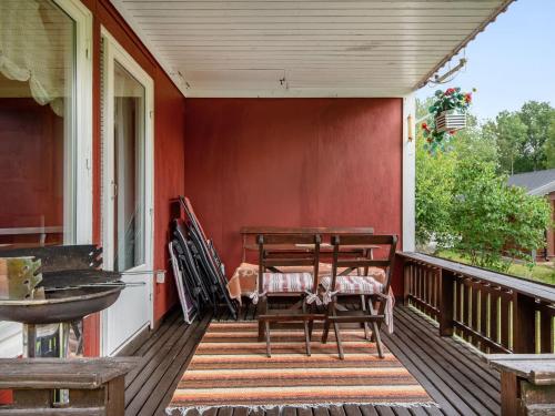 eine Veranda mit einer Bank und einem Tisch darauf in der Unterkunft Chalet Västanvik Snickarhagen - OST047 by Interhome in Motala