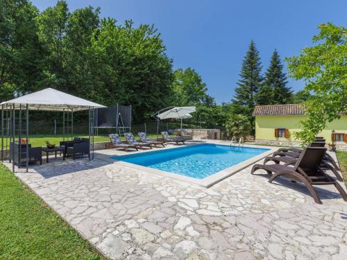 a swimming pool with chairs and umbrellas in a yard at Holiday Home Donada - LBN347 in Nedeščina