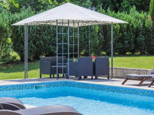 an umbrella over a swimming pool with a table and chairs at Holiday Home Donada - LBN347 in Nedeščina